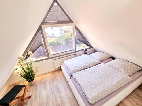sypialnia z łóżkiem i dużym oknem w obiekcie Haus Findling w Zingst