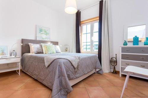 a bedroom with a bed and a dresser and a window at Delfimar Suite Alvor Apartment in Alvor