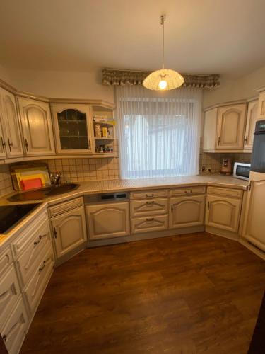 a kitchen with white cabinets and a large window at Ferienhaus Löhr mit Treppenlift in Koblenz