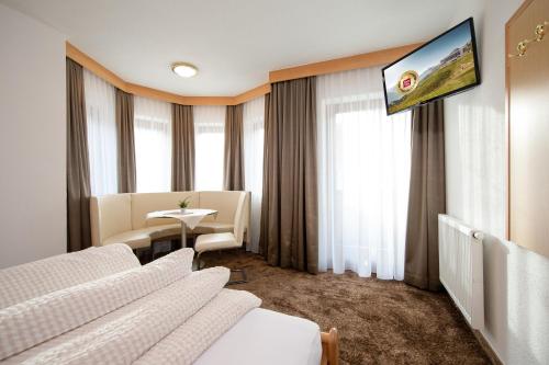 a hotel room with two beds and a flat screen tv at Tonis Ferienheim in Sölden