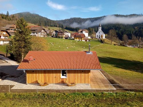 ein Holzgebäude mit rotem Dach auf einem Feld in der Unterkunft s'heimatgfühl in Schwarzenberg