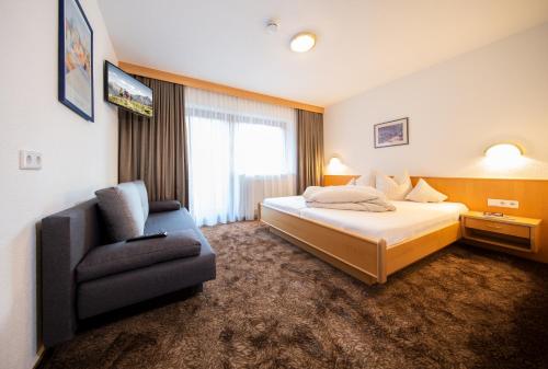a hotel room with a bed and a chair at Tonis Ferienheim in Sölden