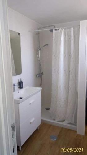 a white bathroom with a shower and a sink at Sol e Praia Alvor 2 in Alvor