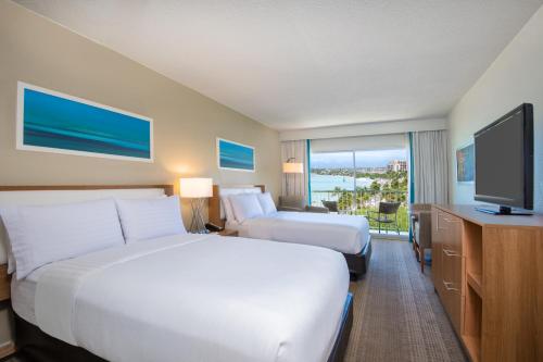 a hotel room with two beds and a flat screen tv at Holiday Inn Resort Aruba - Beach Resort & Casino, an IHG Hotel in Palm-Eagle Beach