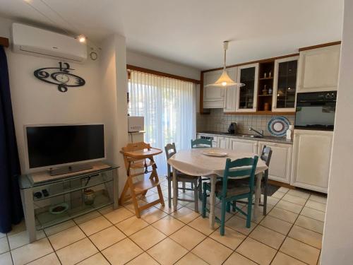 uma cozinha e sala de jantar com uma mesa e uma televisão em Casa Sheila em Quartino