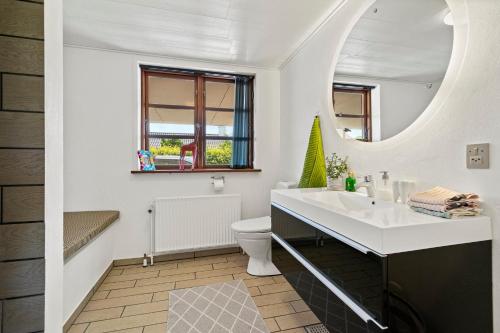 a bathroom with a sink and a toilet and a mirror at Rosengren Residence, Fireplace & barbecue in Billund