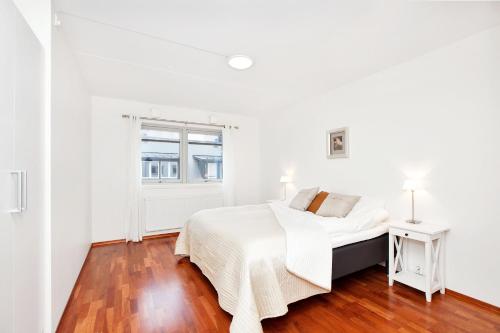 a white bedroom with a bed and a window at BJØRVIKA APARTMENTS, Teaterplassen, Oslo city center in Oslo
