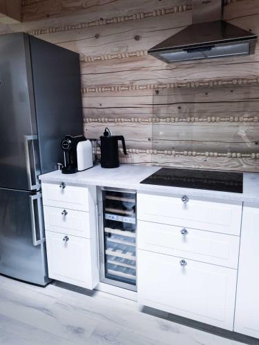 a kitchen with white cabinets and a refrigerator at Koniakowo - dom Forest in Koniaków