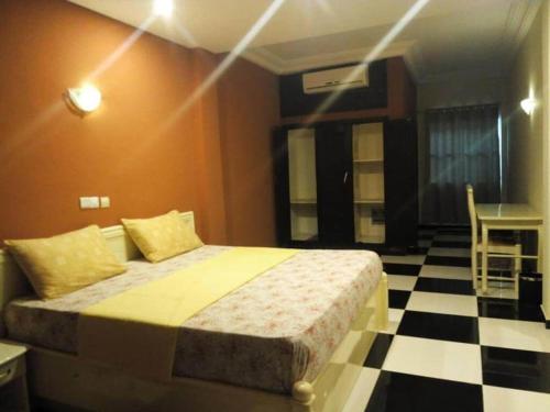 1 dormitorio con 1 cama y suelo blanco y negro a cuadros en Mosaly Hotel PK10, en Porto Novo