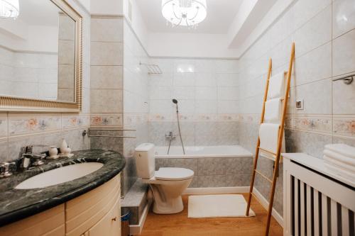a bathroom with a sink and a toilet and a tub at Apartament Rynek Więzienna in Wrocław