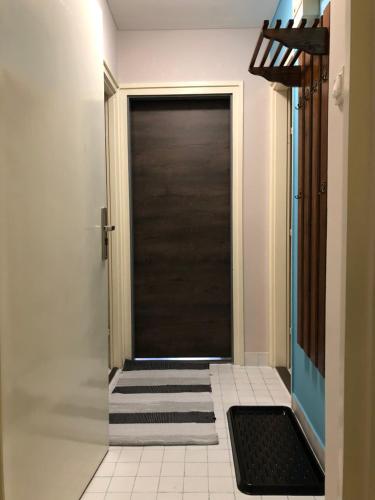 a black door in a hallway with a tile floor at Happy Bunnies Apartman I - Gunarasfürdő in Dombóvár