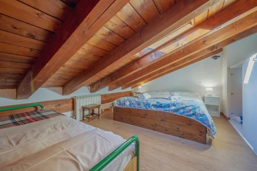 a bedroom with two beds and wooden ceilings at Appartamento Adèle- CIR 0063 in La Thuile