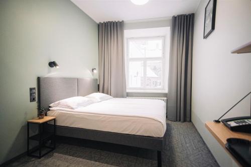 a small bedroom with a bed and a window at Rija Old Town Hotel in Tallinn