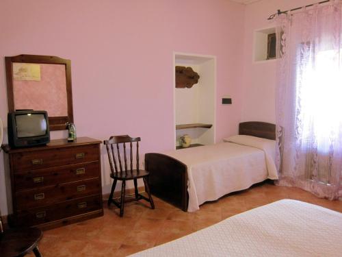 a bedroom with two beds and a dresser and a mirror at agriturismo u zu peppino in Lipari