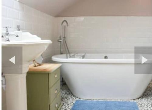 y baño con bañera, lavamanos y bañera. en The Stables Holiday Let en Low Etherley