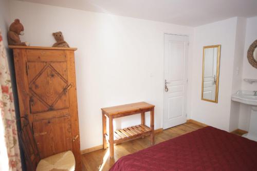 1 dormitorio con 1 cama, armario de madera y mesa en Room for two in a house of the XVII century - N2 Chez Jean Pierre, en Villar-dʼArène