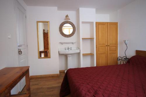 a bedroom with a bed and a sink and a mirror at Room for two in a house of the XVII century - N2 Chez Jean Pierre in Villar-dʼArène