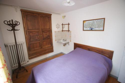 una camera con letto viola e armadio in legno di Room for two in a house of the XVII century - N3 Chez Jean Pierre a Villar-dʼArène