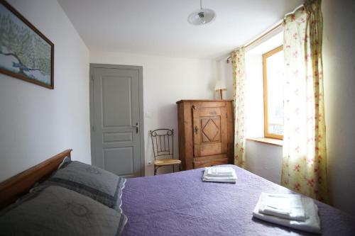 une chambre avec un lit violet et une fenêtre dans l'établissement Room for two in a house of the XVII century - N3 Chez Jean Pierre, à Villar-dʼArêne