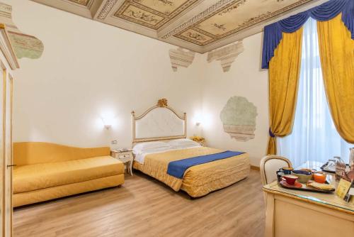 a bedroom with a bed and a couch at Hotel Porta Faenza in Florence
