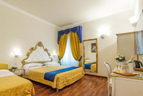 a hotel room with two beds and a mirror at Hotel Porta Faenza in Florence