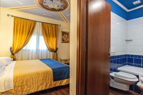 a bathroom with a bed and a toilet in a room at Hotel Porta Faenza in Florence