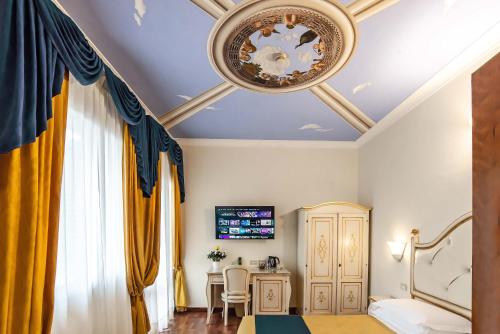 a bedroom with a ceiling with a chandelier at Hotel Porta Faenza in Florence