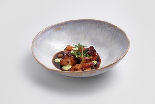 a silver bowl filled with food on a white background at Áurea Palacio de Correos by Eurostars Hotel Company in Logroño