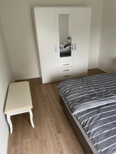 a bedroom with a bed and a table and a cabinet at Doddy‘s Stuuv in Niesgrau