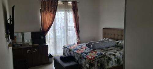 KedatonにあるBandar Lampung Villaのベッドルーム(ベッド1台、窓付)