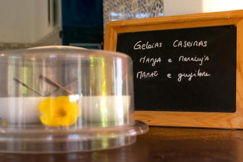 a glass container with an orange in front of a chalkboard at Pousada Casa Do Cocotier in São Miguel do Gostoso