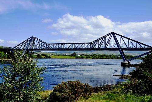 a bridge that is over a river with water at Dana Villa Holiday Accommodation in Oban