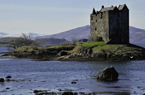 a castle on an island in a body of water at Dana Villa Holiday Accommodation in Oban