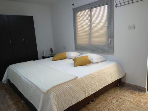 KOMODO ALOJAMIENTO- hostal autoservicio, ubicado cerca al centro - baño privado, wifi , cama 2x2 y agua caliente y cocina compartidaにあるベッド