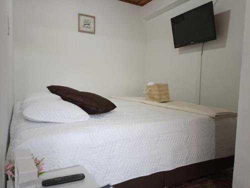 KOMODO ALOJAMIENTO- hostal autoservicio, ubicado cerca al centro - baño privado, wifi , cama 2x2 y agua caliente y cocina compartidaにあるベッド
