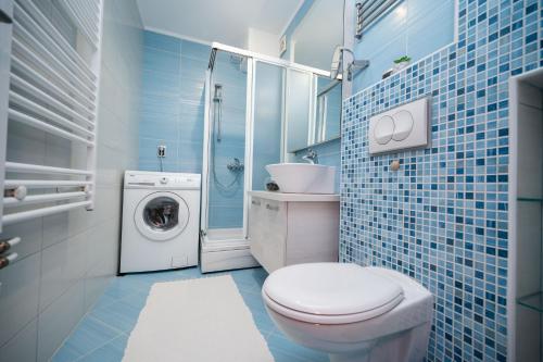 a bathroom with a toilet and a washing machine at Bright 1BDR Apartment in the City Center in Sarajevo