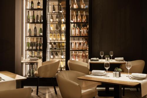 a restaurant with a table and chairs and wine bottles at Áurea Palacio de Correos by Eurostars Hotel Company in Logroño