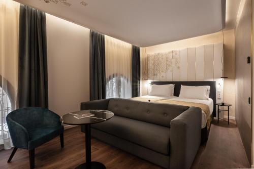 a hotel room with a bed and a couch at Áurea Palacio de Correos by Eurostars Hotel Company in Logroño