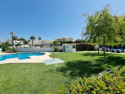 a yard with a swimming pool and a tree at SUPERBE T3 RIVIERA DEL SOL Plage et commerces 4mn in Mijas