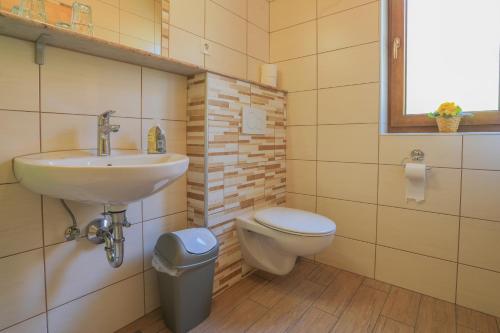 a bathroom with a toilet, sink, and tub at Farm Holidays Povsin in Bled