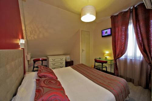 a bedroom with a bed and a table and a window at Hotel Restaurant Laborderie in Tamniès