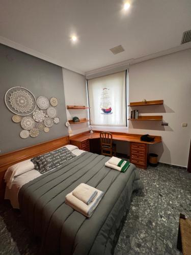 a bedroom with a bed and a desk and a window at TORREPEREA- Piso completo in Jaén