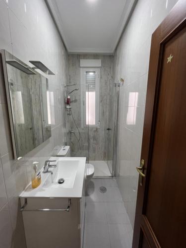 a white bathroom with a sink and a shower at TORREPEREA- Piso completo in Jaén