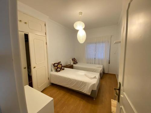 um pequeno quarto com 2 camas e uma janela em Zulla House na Nazaré