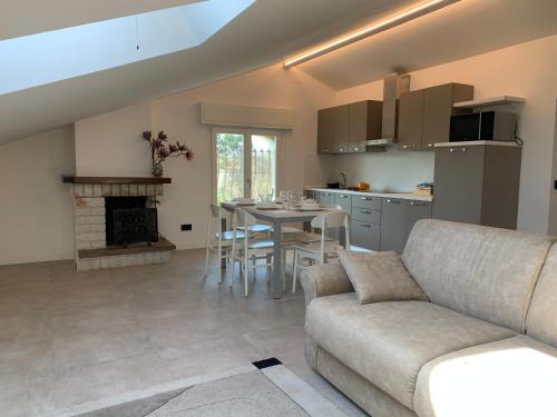 een woonkamer met een bank en een tafel en een keuken bij CasaLO' Igea in Bellaria-Igea Marina