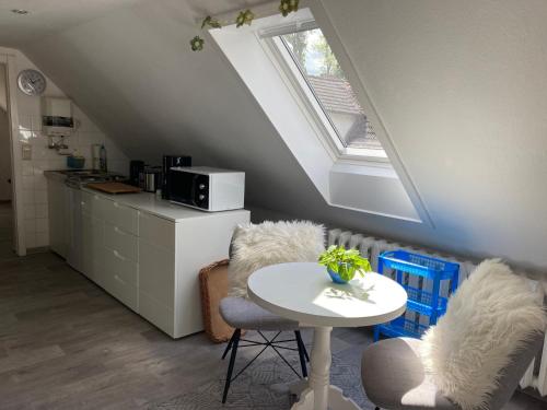 eine Küche mit einem Tisch, 2 Stühlen und einem Fenster in der Unterkunft Ferienwohnung Rosi Stoppa in Burg