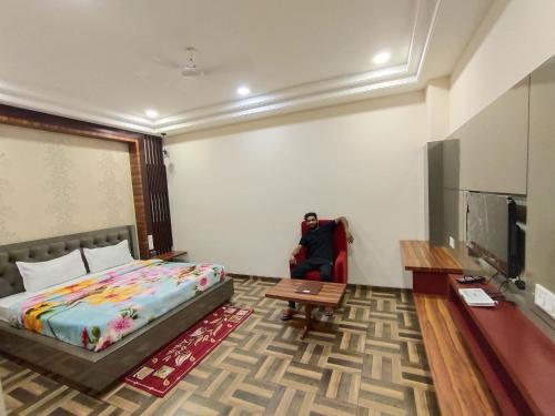 a bedroom with a bed and a table and a tv at DUDI HOTEL in Bikaner