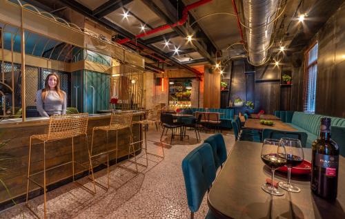 a restaurant with tables and chairs and a woman in the background at Stay Inn Hotel Jerusalem in Jerusalem