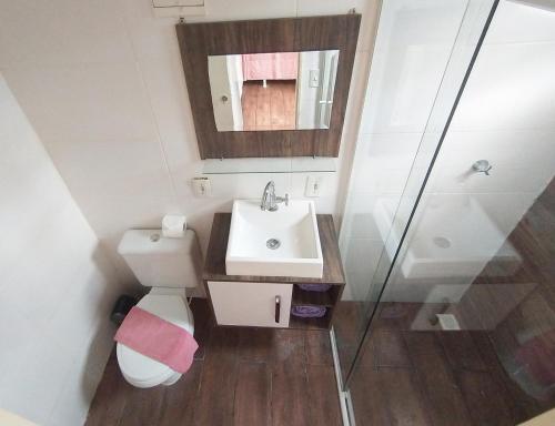 a bathroom with a sink and a toilet and a mirror at Marco Zero Containers 4 in Balneário Camboriú