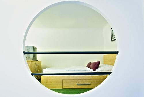 a bedroom with a bed through a round mirror at The Fashion Street Apartment in Budapest